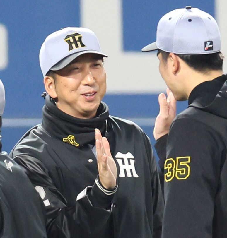 　才木（右）と勝利のタッチを交わす藤川監督