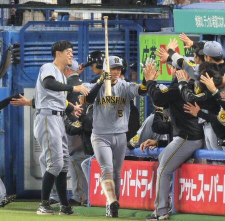 　１１回、勝ち越し２ランを放ちナインとタッチする近本（撮影・棚橋慶太）