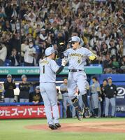 　８回、逆転２ランを放ち、森下（左）とハイタッチを交わす佐藤輝（撮影・西岡正）