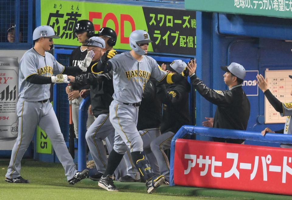 　８回、逆転２ランを放ち、藤川監督（右）に迎えられる佐藤輝（中央）＝撮影・伊藤笙子