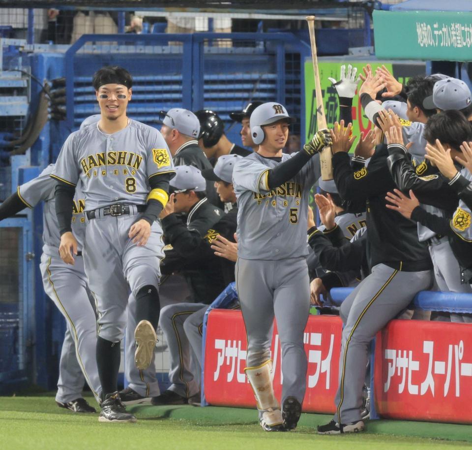 　１１回、勝ち越し２ランを放ちナインとタッチする近本（撮影・棚橋慶太）