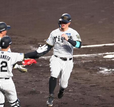 　１回、前川の適時打で生還し、森下らとタッチを交わす佐藤輝（撮影・北村雅宏）
