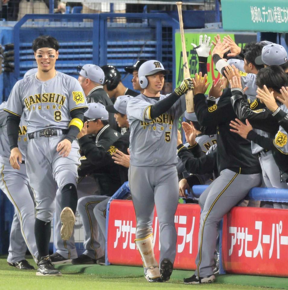 　１１回、勝ち越し２ランを放ちナインとタッチする近本（撮影・棚橋慶太）