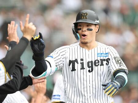 　５回、３ランを放ち、ナインとタッチを交わす佐藤輝（撮影・中田匡峻）