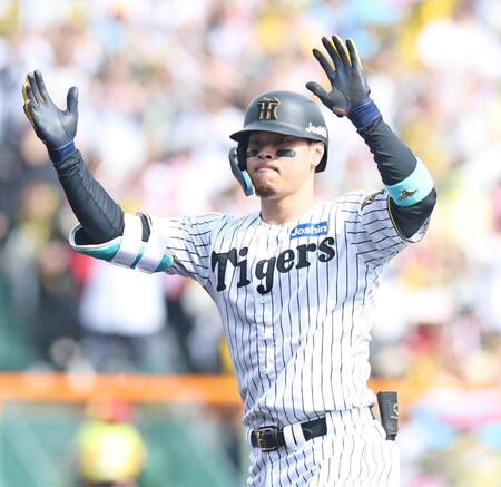 　３回、ライトへ適時二塁打を放ち、塁上で手をたたく佐藤輝（撮影・中田匡峻）