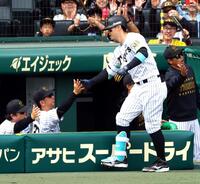 　１回、２ランを放った佐藤輝を迎える藤川監督（撮影・山口登）