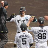 　５回、３ランを放った佐藤輝は生還し、ハイタッチを交わす（撮影・北村雅宏）