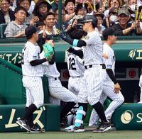 　１回、伊原（左）は先制２ランを放った佐藤輝を迎える（撮影・山口登）