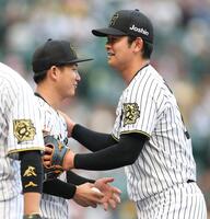 　伊原（左）にウイニングボールを手渡す岡留（撮影・中田匡峻）