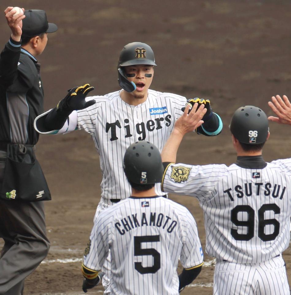 　５回、３ランを放った佐藤輝は生還し、ハイタッチを交わす（撮影・北村雅宏）