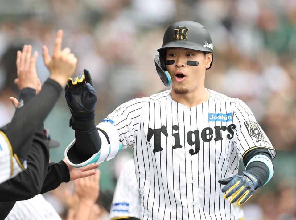 　５回、３ランを放ち、ナインとタッチを交わす佐藤輝（撮影・中田匡峻）