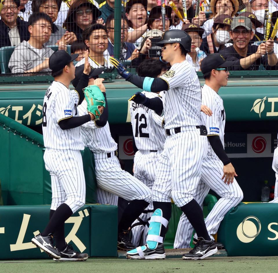 　１回、伊原（左）は先制２ランを放った佐藤輝を迎える（撮影・山口登）