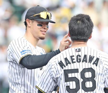 　５回の守備を前に前川の顔に付いた汚れを取る佐藤輝（撮影・中田匡峻）