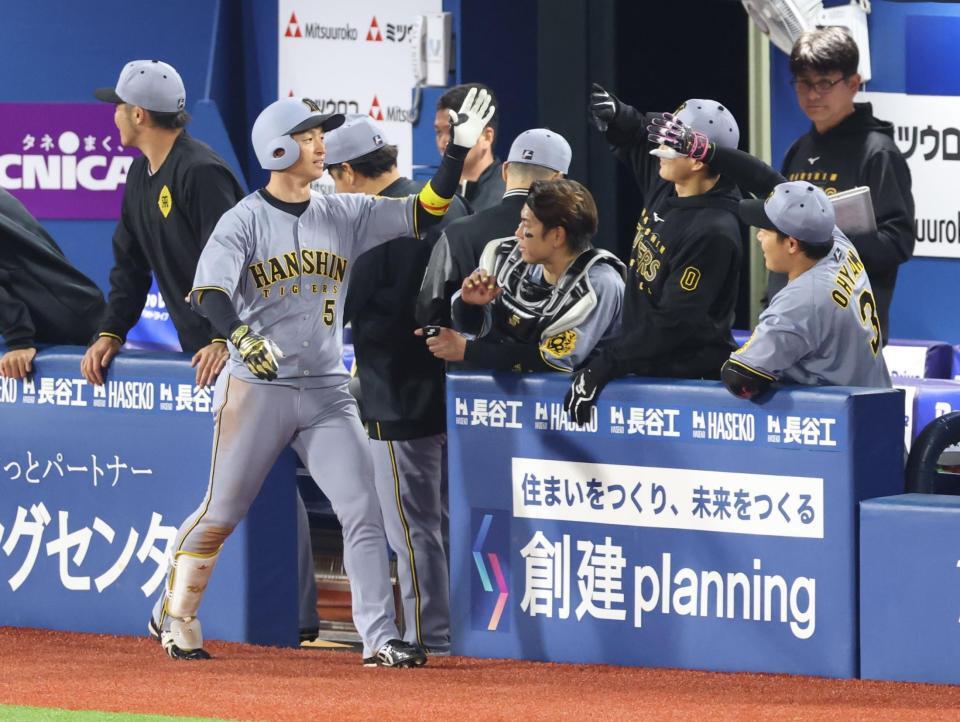 　７回、右越えソロを放ちナインに迎えられる近本（撮影・金田祐二）