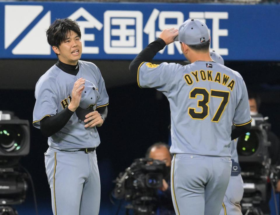 　７回、降板後ピンチを断ち切った及川（右）を迎える才木（撮影・伊藤笙子）