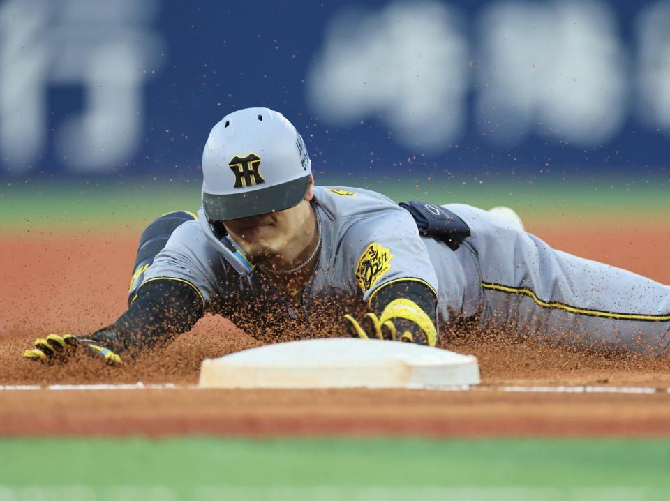 　２回、三塁打を放ちヘッドスライディングを決める佐藤輝（撮影・田中太一）