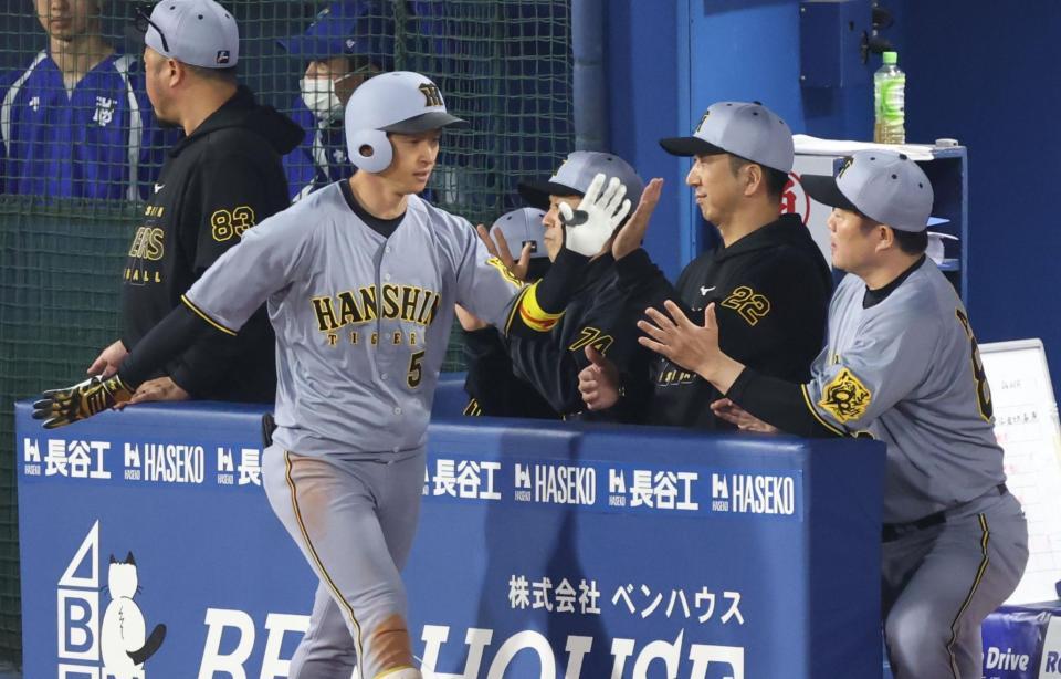 　７回、右越えソロを放った近本を迎える藤川監督（撮影・金田祐二）