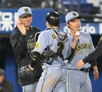 　延長戦を制し、梅野（中央）を笑顔で迎える藤川監督（左）と島本（撮影・伊藤笙子）