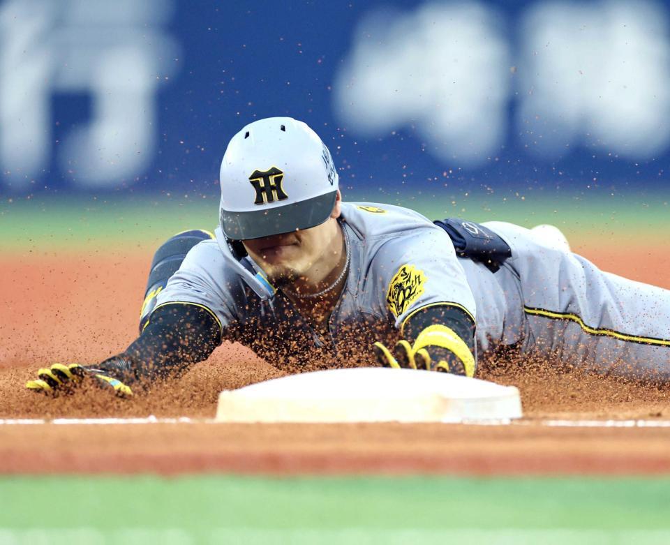 　２回、三塁打を放ちヘッドスライディングをする佐藤輝（撮影・田中太一）