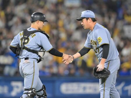 　プロ初セーブをあげ、坂本（左）と握手を交わす桐敷（撮影・伊藤笙子）