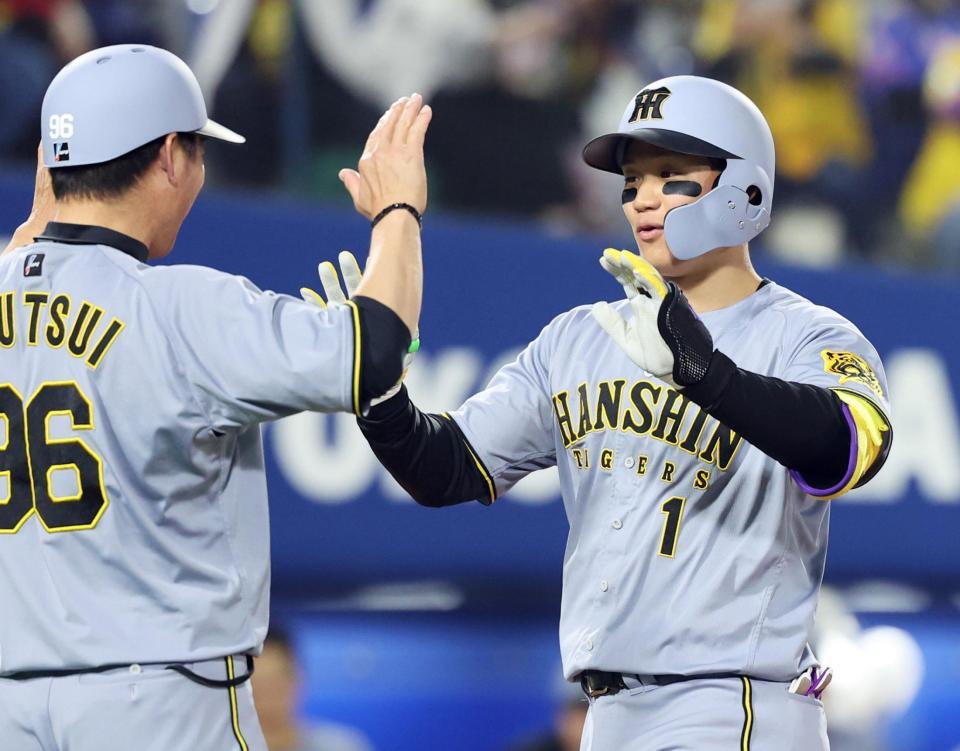 　７回、勝ち越しの２ランを放ち、コーチとタッチを交わす森下