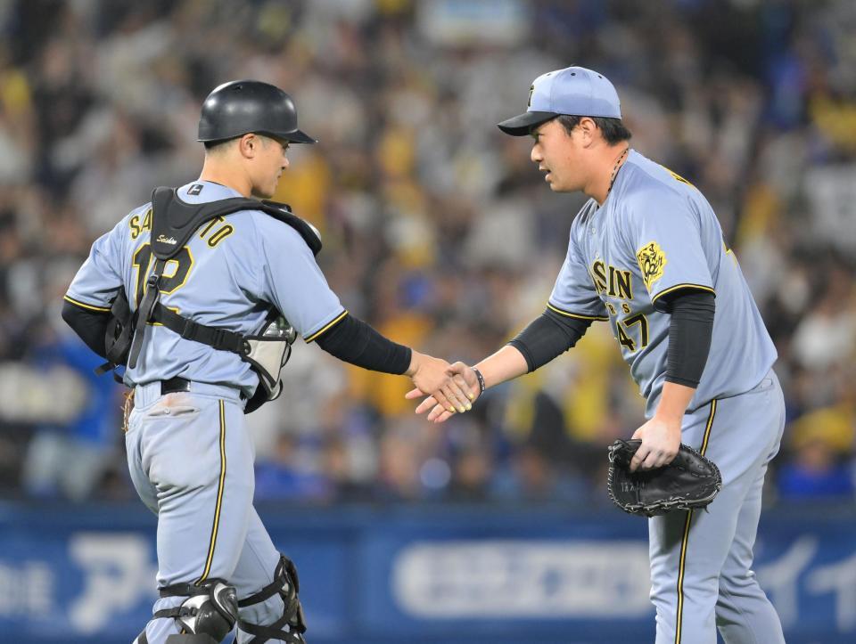 　プロ初セーブをあげ、坂本（左）と握手を交わす桐敷（撮影・伊藤笙子）