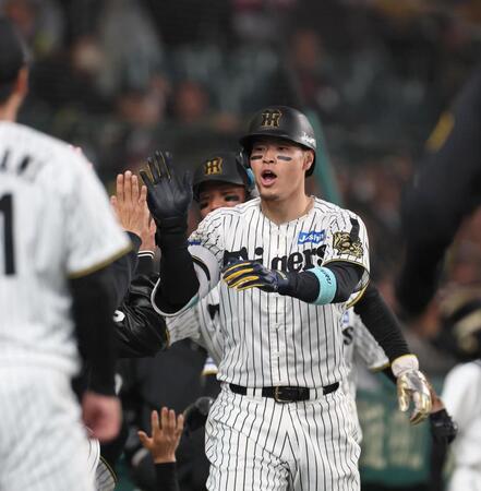 　３回、３ランを放ち、ベンチ前でタッチを交わす佐藤輝（撮影・北村雅宏）