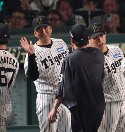 　今季４勝目を挙げた村上を迎える藤川監督（左）＝撮影・中田匡峻