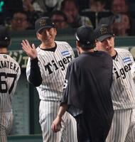 　今季４勝目を挙げた村上を迎える藤川監督（左）＝撮影・中田匡峻