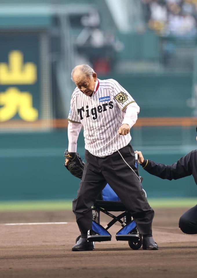 　車椅子から立ち上がって、ファーストピッチセレモニーをする江夏豊氏（撮影・山口登）