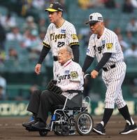 　ファーストピッチセレモニーを務め、退場する江夏豊氏（左下）、田淵幸一氏（左上）、掛布雅之氏＝２５日