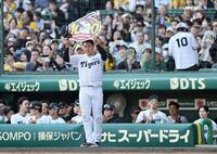 　通算１０００試合出場を達成し、ナインに祝福されながらボードを掲げる大山（撮影・田中太一）