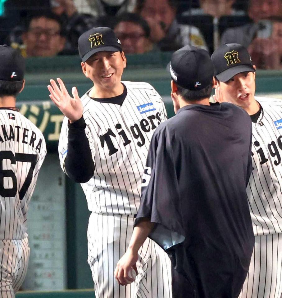 　今季４勝目を挙げた村上を迎える藤川監督（左）