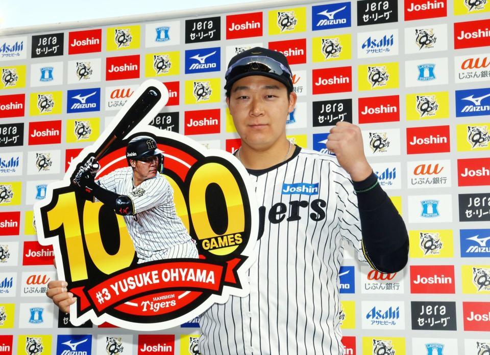 　お立ち台で大山は１０００試合出場のボードを手にポーズを決める（撮影・山口登）