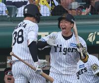 　８回、中犠飛を放った小幡（左）を迎える近本（撮影・中田匡峻）