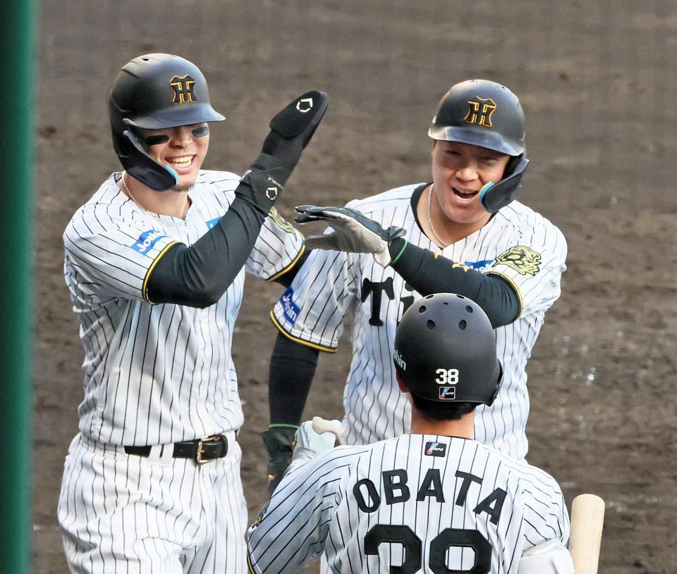 　８回、坂本の２点適時二塁打で生還し笑顔を見せる大山（右）と佐藤輝（撮影・立川洋一郎）