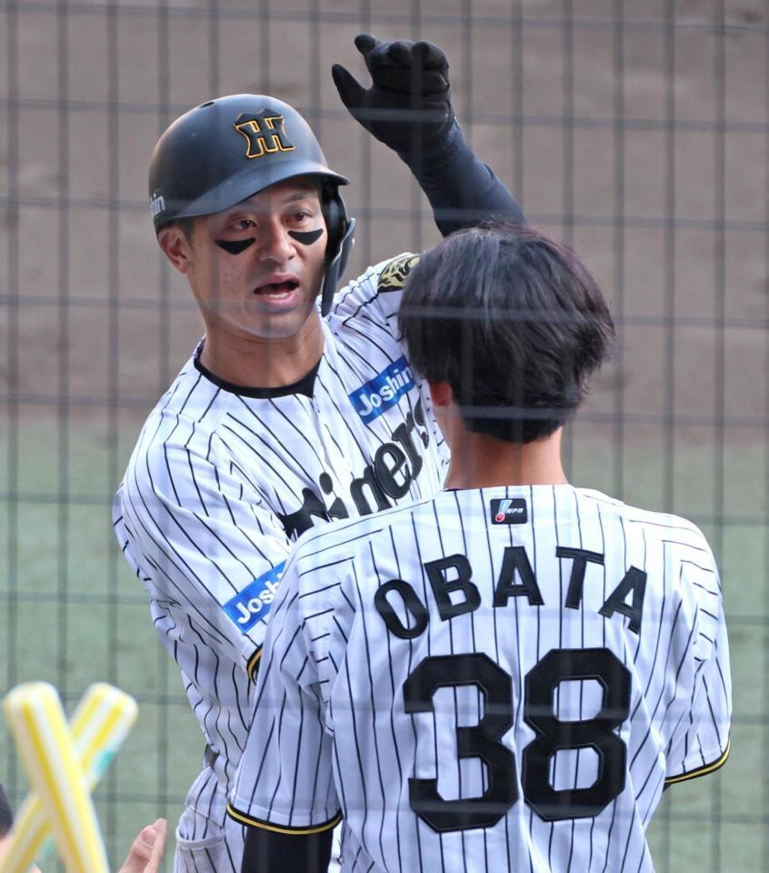 　５回、代打・渡辺の同点適時打で生還し小幡（３８）の出迎えを受ける坂本（撮影・立川洋一郎）