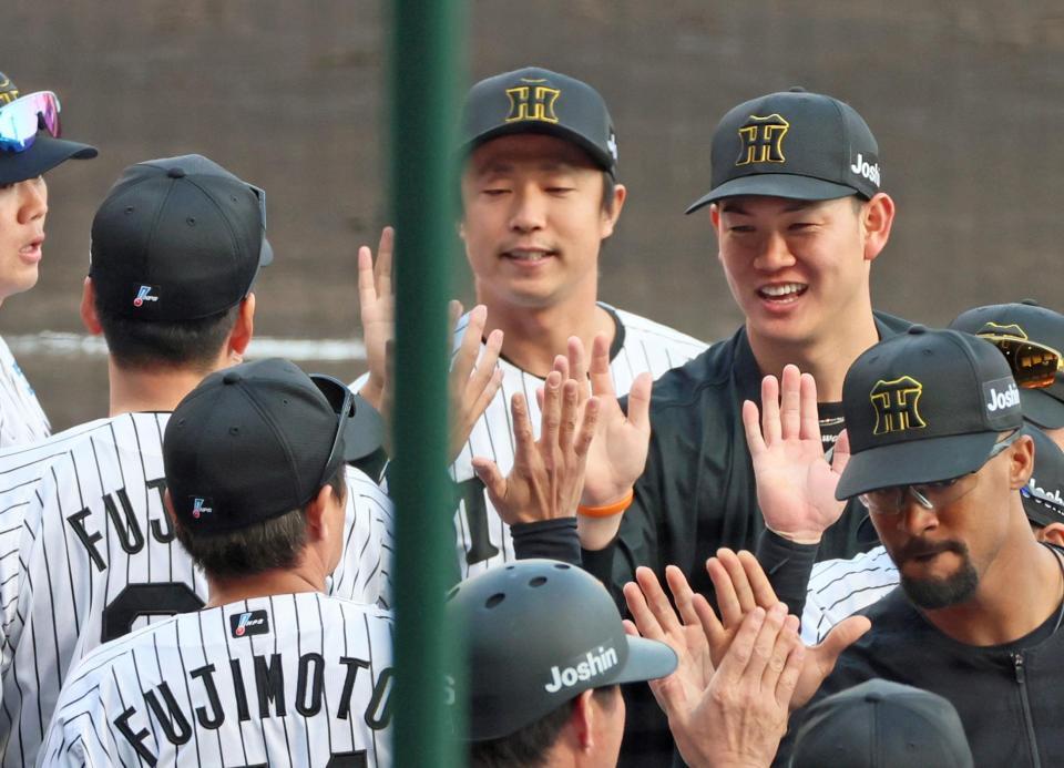 　勝利投手となり藤川監督（左）とタッチを交わす及川（撮影・立川洋一郎）