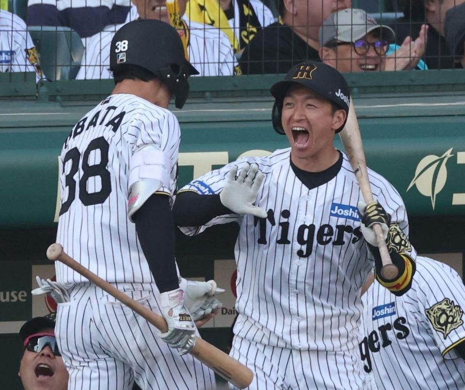 　８回、中犠飛を放った小幡（左）を迎える近本（撮影・中田匡峻）