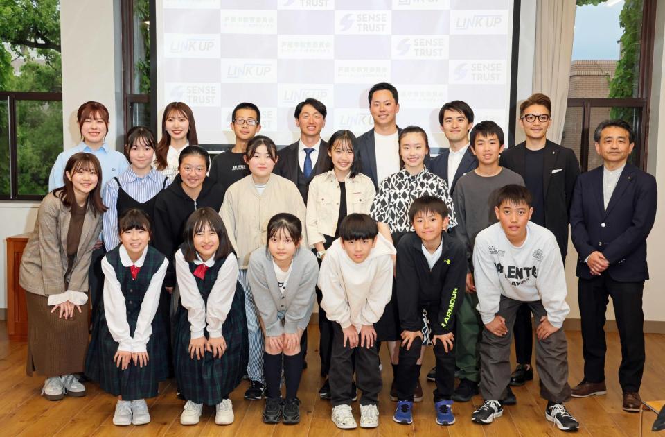 　教育プログラム「未来につなぐプロジェクト」に参加し、子どもたちと写真に納まる近本（後列中央）
