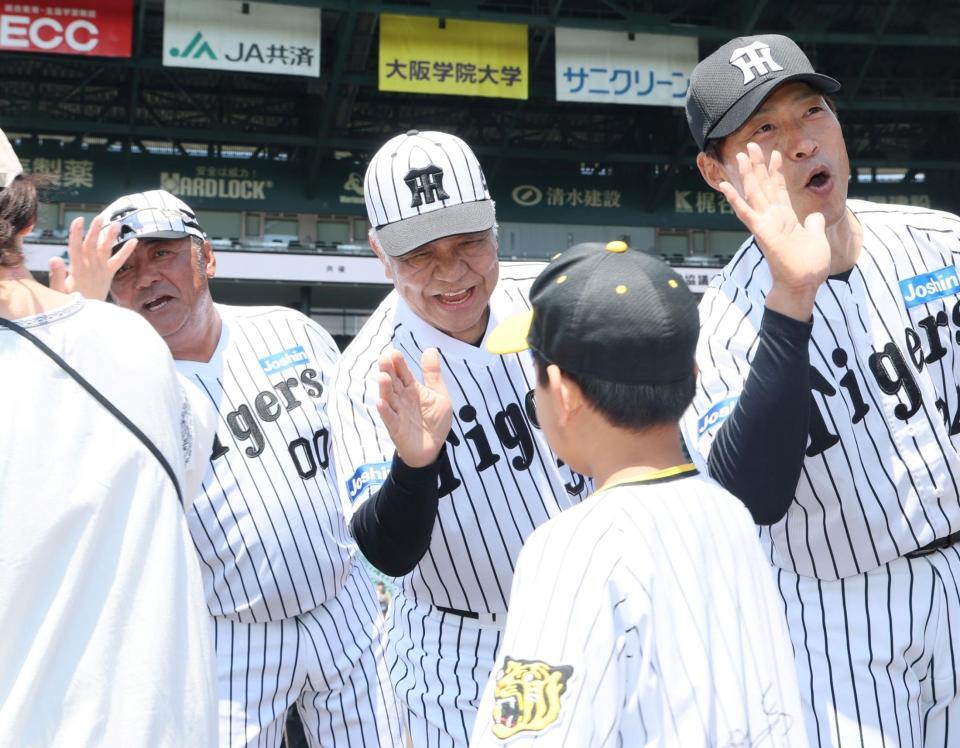 　参加者とタッチをかわす掛布雅之ＯＢ会長（中央）＝撮影・石井剣太郎