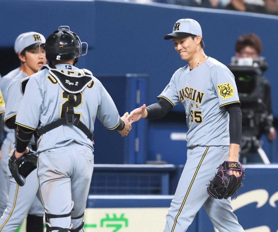 　７回、無失点に抑えて梅野と握手を交わす湯浅（右）（撮影・北村雅宏）