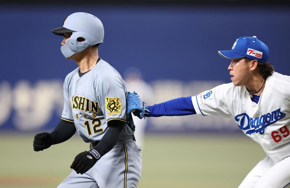 　３回、近本の二ゴロで本塁を狙うも、挟まれ三浦（右）にタッチアウトされる三走の坂本（撮影・中田匡峻）