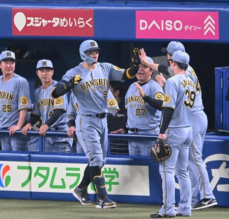 　５回、１０号同点ソロを放ちナインとタッチを交わす佐藤輝（撮影・飯室逸平）