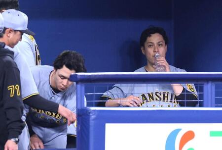 　５回、勝ち越しを許し、ベンチでペットボトルを口にする大竹（右）。右から２人目は小幡（撮影・北村雅宏）