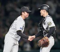 　完封勝利を挙げた村上（左）は坂本と握手を交わす（撮影・田中太一）