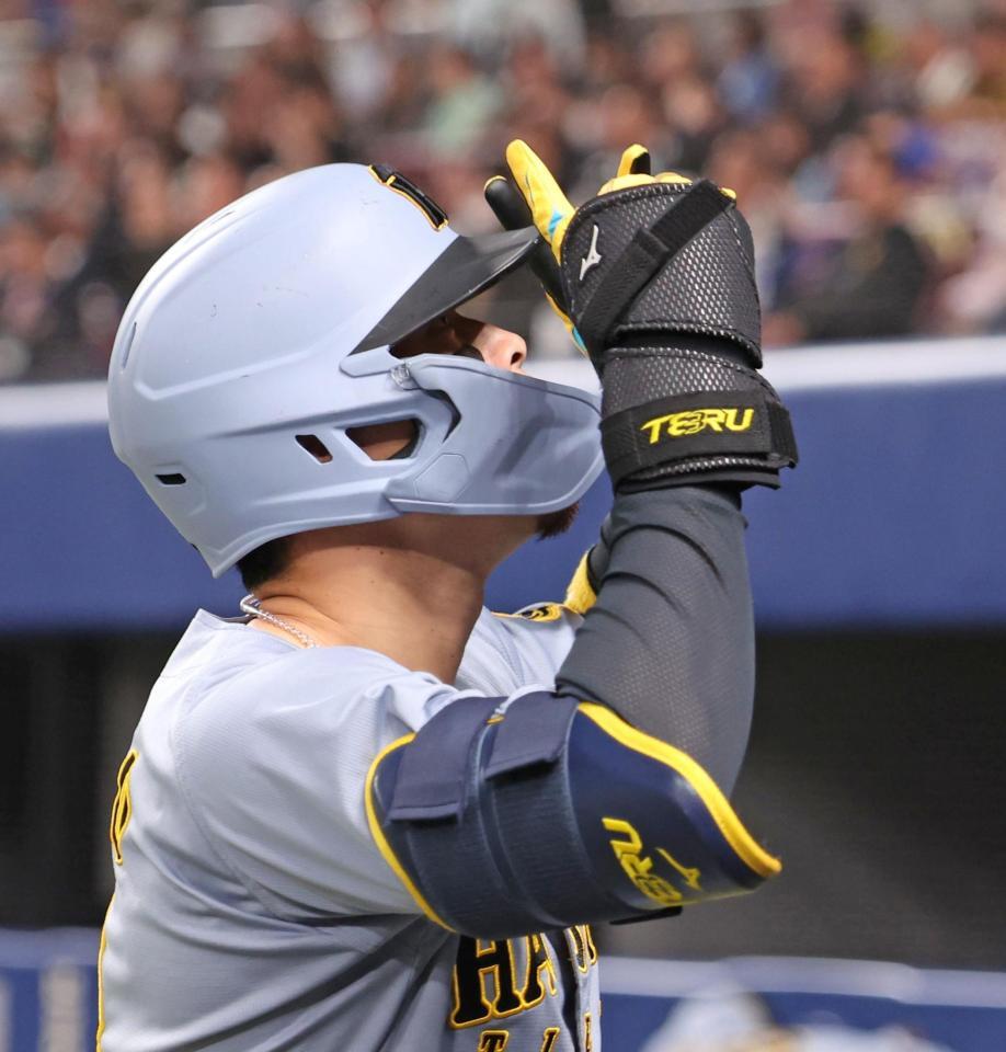 　５回、レフトへ同点ソロを放ち、ベンチ前でポーズを決める佐藤輝（撮影・中田匡峻）