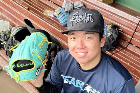 　試合用グラブと同じ文字を刺繍した練習用グラブを披露する村上