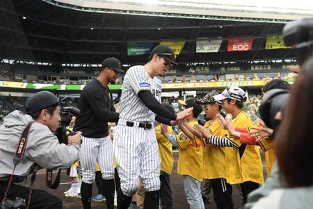 　子どもたちとタッチを交わすデュプランティエ（左）と佐藤輝（撮影・西田忠信）