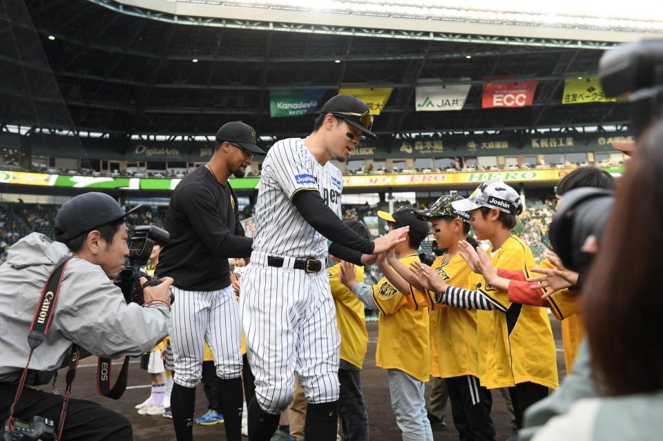 　子どもたちとタッチを交わすデュプランティエ（左）と佐藤輝（撮影・西田忠信）